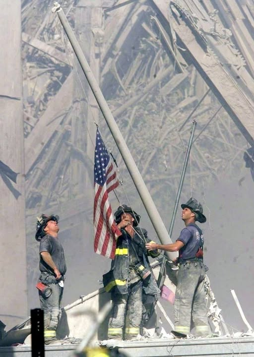 Firemen raise flag over WTC rubble